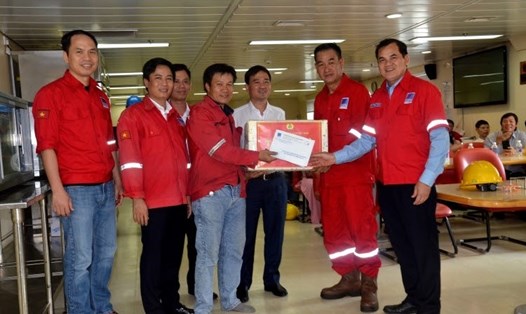 Đồng chí Vũ Anh Tuấn và đồng chí Hồ Trọng Thoán tặng quà cho người lao động trên giàn PV Drilling V. Ảnh: Hồng Thắm
