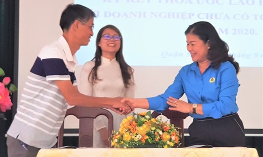 Bà Lê Thị Bích Hạnh - Chủ tịch LĐLĐ quận 5, TPHCM (bên phải) - cùng Giám đốc Cty TNHH Tư vấn và đầu tư DTL ký, trao thỏa ước lao động tập thể. Ảnh: Đức Long