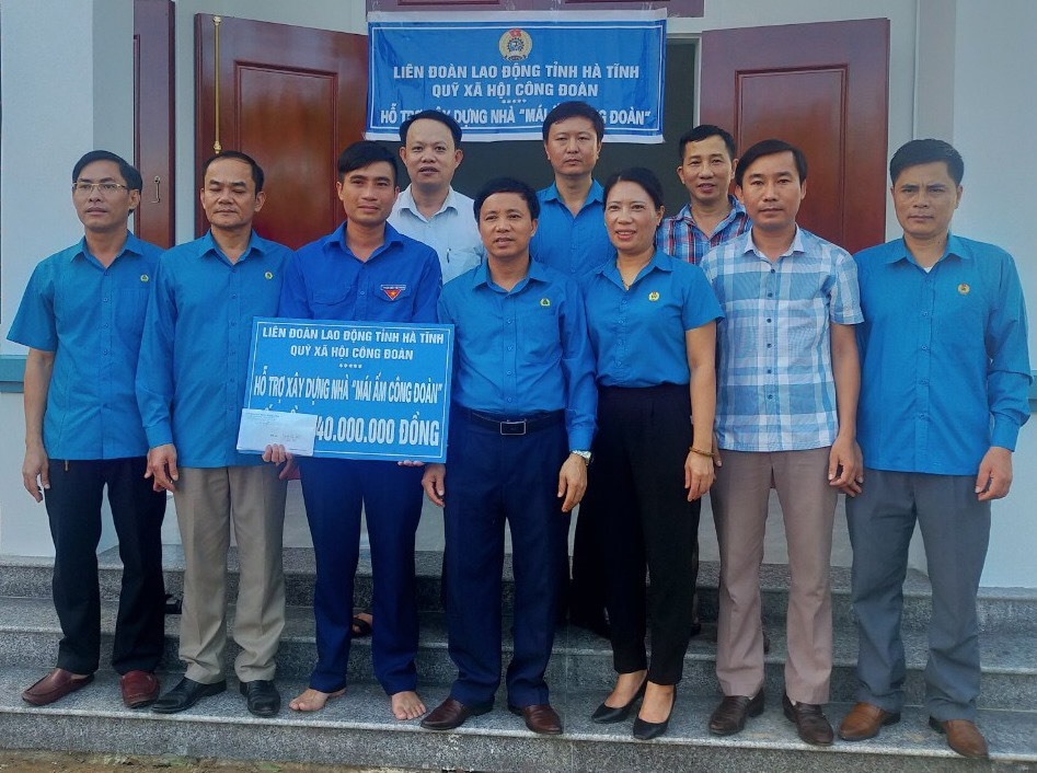 Ông Nguyễn Văn Danh - Chủ tịch LĐLĐ Hà Tĩnh (thứ 4 từ phải qua trái) trao tiền hỗ trợ làm nhà Mái ấm công đoàn cho đoàn viên Nguyễn Văn Thiều. Ảnh: CĐ.