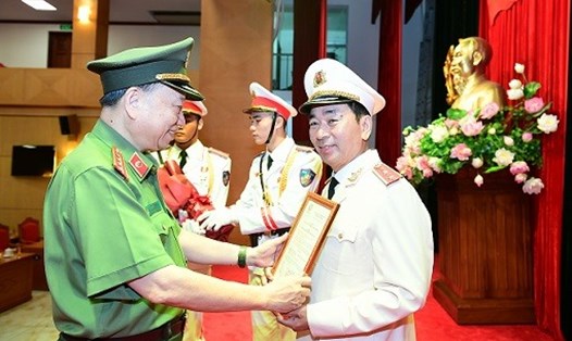Bộ trưởng Tô Lâm trao Quyết định của Chủ tịch nước thăng cấp bậc hàm từ Thiếu tướng lên Trung tướng đối với ông Trần Quốc Tỏ. Ảnh BCA