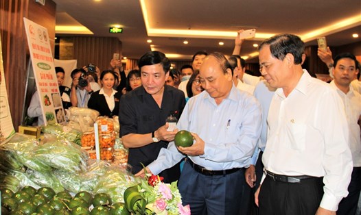Thủ tướng Chính phủ Nguyễn Xuân Phúc đi thăm một gian hàng nông sản của một doanh nghiệp ở Đắk Lắk. Ảnh Kim Bảo
