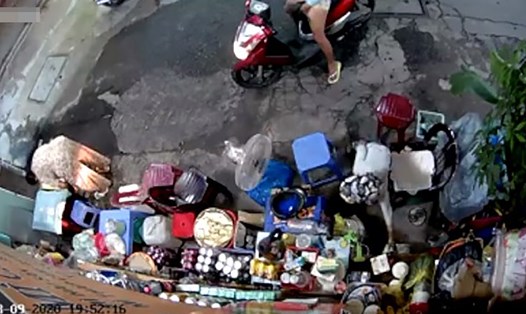 Hình ảnh camera ghi lại cảnh người phụ nữ đi xe tay ga xúi đứa bé lấy trộm túi tiền của bà bán nước. Ảnh cắt từ clip.