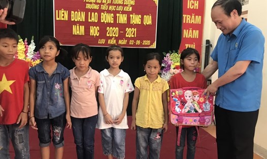 Đồng chí Nguyễn Tử Phương-Chủ tịch LĐLĐ tỉnh Nghệ An tặng cặp sách cho học sinh tại huyện Tương Dương. Ảnh: Phúc Đông
