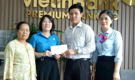 Đại diện LĐLĐ tỉnh Bắc Giang trao số tiền tiết kiệm cho gia đình cháu Mạnh. Ảnh: KT