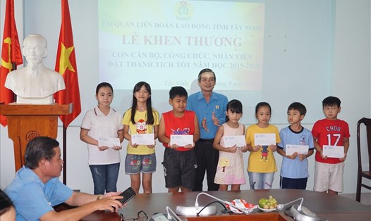 Ông Phan Văn Bua – Phó Chủ tịch LĐLĐ tỉnh trao khen thưởng cho các cháu học sinh cấp 1 đạt thành tích. Ảnh Quốc Tiến