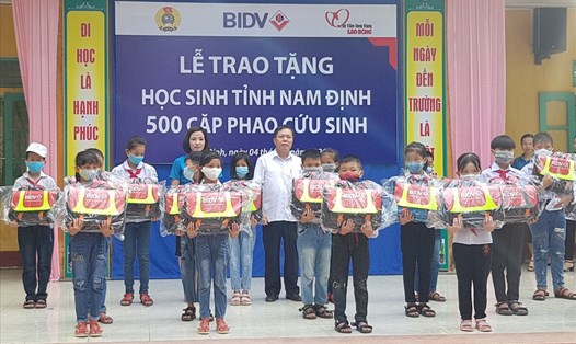 Đại diện lãnh đạo LĐLĐ tỉnh Nam Định và Ngân hàng BIDV trao cặp phao cứu sinh cho học sinh Trường Tiểu học Thọ Nghiệp. Ảnh: NT