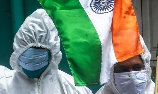 Lực lượng tuyến đầu chống COVID-19 trong trang phục bảo hộ cầm quốc kỳ Ấn Độ trong lễ kỷ niệm Ngày Độc lập hôm 15.8.2020 ở Kolkata. Ảnh: AFP.