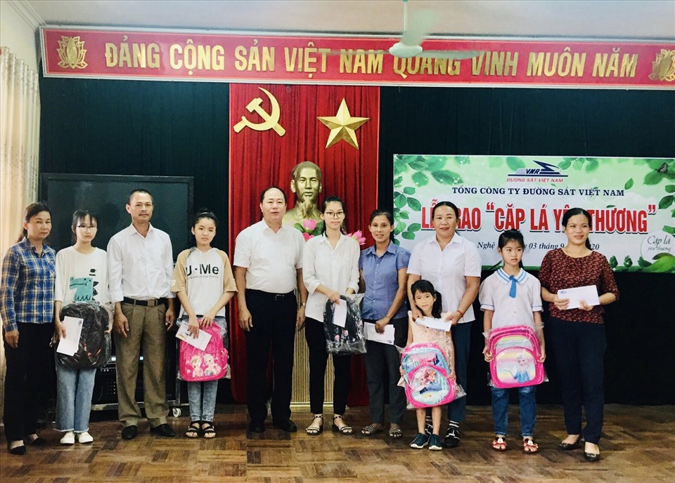 Ông Vũ Anh Minh- Bí thư Đảng ủy, Chủ tịch Hội đồng thành viên Tổng Công ty (thứ 5 từ trái sang) trao biển hỗ trợ “Cặp lá yêu thương”. Ảnh: CĐ ĐS