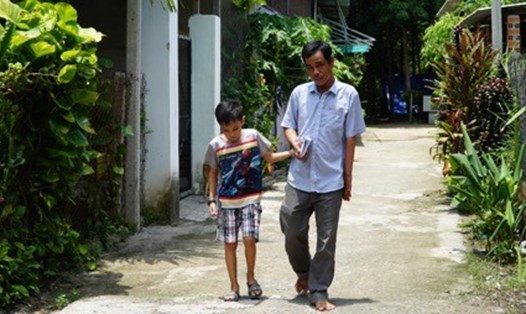 Hai cha con bé Bình Minh dắt tay nhau đến trường. Ảnh BH