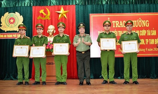 Đại tá Phạm Văn Sơn, Giám đốc Công an tỉnh Ninh Bình biểu dương khen thưởng và tặng Giấy khen cho 5 cá nhân có thành tích trong điều tra khám phá vụ cướp tài sản. Ảnh: NT