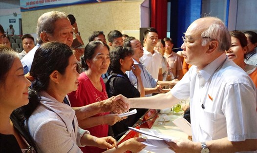 Người dân Thủ Thiêm gửi đơn kiến nghị đến ông Phan Nguyễn Như Khuê (bên phải) - Trưởng ban Tuyên giáo Thành ủy TPHCM sau một buổi tiếp xúc cử tri. Ảnh: Minh Quân