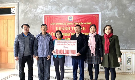 Lãnh đạo LĐLĐ huyện Tân Yên trao kinh phí hỗ trợ xây nhà cho gia đình chị Huyền. Ảnh: Tân Yên
