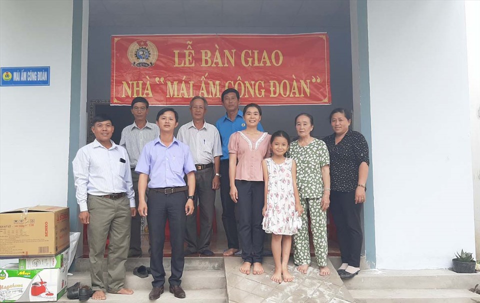 Đại biểu chụp ảnh lưu niệm cùng gia đình chị Phan Thu Thuế tại lễ bàn giao Mái ấm Công đoàn. Ảnh: Trí Dũng