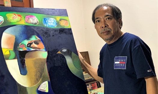 Nguyễn Quang Thiều bên giá vẽ tại nhà. Ảnh: Nhân vật cung cấp