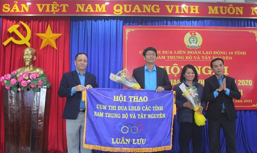 Ông Rơ Chăm Long - Chủ tịch LĐLĐ tỉnh Kon Tum bàn giao cờ luân lưu trưởng cụm thi đua. Ảnh TT