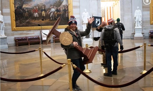 Ảnh người đàn ông tươi cười cuỗm bục phát biểu của Chủ tịch Hạ viện Mỹ Nancy Pelosi gây bão sau vụ hỗn loạn ở tòa nhà Quốc hội Mỹ ngày 6.1. Ảnh: AFP/Getty.