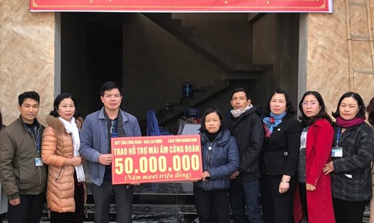 Đại diện Quỹ TLV Lao Động trao tiền hỗ trợ của quỹ cho gia đình cô giáo Vũ Bình Yên tại lễ bàn giao nhà "Mái ấm Công đoàn". Ảnh: Nguyễn Hùng