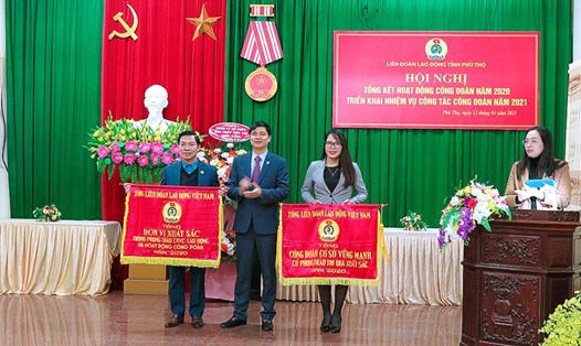 Phó Chủ tịch Tổng LĐLĐ Việt Nam Ngọ Duy Hiểu trao Cờ thi đua của Tổng LĐLĐ Việt Nam cho các tập thể đạt thành tích xuất sắc năm 2020. Ảnh: Hoàng