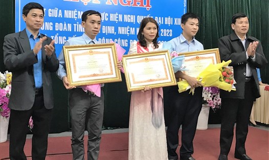 Chủ tịch LĐLĐ Bình Định Nguyễn Mạnh Hùng (trái) trao bằng khen của Thủ tướng Chính phủ cho 3 cá nhân có thành tích xuất sắc.