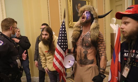Nghi phạm khoác lông thú đội mũ sừng bò xông vào Điện Capitol. Ảnh: AFP