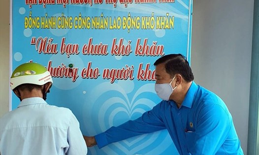 Chủ tịch LĐLĐ tỉnh Cà Mau Võ Thanh Tòng hướng dẫn NLĐ sử dụng ATM gạo miễn phí (ảnh Nhật Hồ)