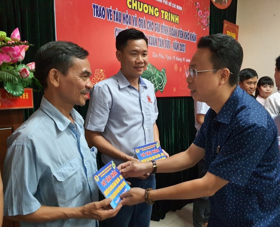 Ông Nguyễn Thành Đô, Trưởng Ban Chính sách - Pháp luật LĐLĐ TPHCM trao vé tàu cho các công nhân. Ảnh: Nam Dương