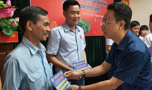 Ông Nguyễn Thành Đô, Trưởng Ban Chính sách - Pháp luật LĐLĐ TPHCM trao vé tàu cho các công nhân. Ảnh: Nam Dương