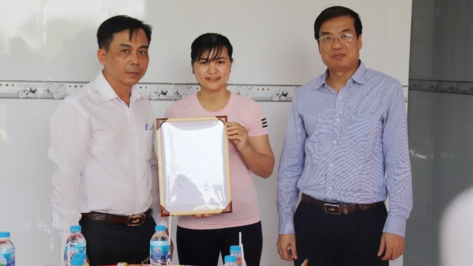 Ông Uông Quang Huy - Trưởng Ban Chính sách Pháp luật Công đoàn Điện lực Việt Nam (phải) trao Quyết định hỗ trợ nhà MÂCĐ cho vợ chồng đoàn viên Trần Văn Ngởi. Ảnh: Xuân Thái