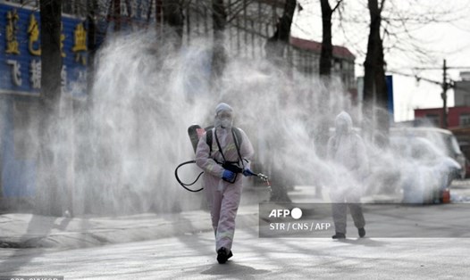 Nhân viên y tế phun khử trùng COVID-19 trên một đường phố tại khu vực có nguy cơ lây nhiễm cao ở thành phố Thạch Gia Trang, tỉnh Hà Bắc, Trung Quốc, ngày 15.1. Ảnh: AFP