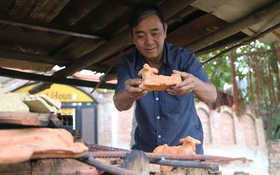 Nghệ nhân làng gốm Thanh Hà nặn tượng trâu mong nhiều may mắn trong năm mới. Ảnh: Đình Dũng
