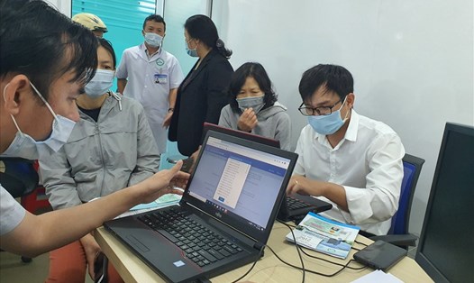 Cán bộ ngành BHXH Việt Nam hướng dẫn người dân cài đặt ứng dụng BHXH số - VssID. Ảnh: Hà Anh
