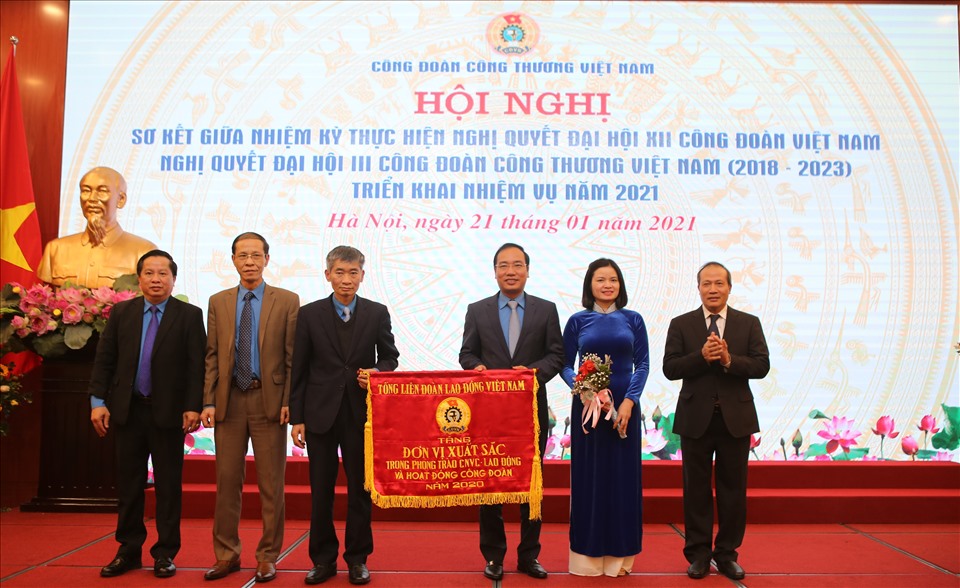Phó Chủ tịch Tổng LĐLĐVN Trần Văn Thuật (thứ ba từ trái sang) và Thứ trưởng Bộ Công Thương (bên phải ảnh) tặng Cờ thi đua của Tổng LĐLĐVN cho Công đoàn Công Thương Việt Nam. Ảnh: Hà Anh