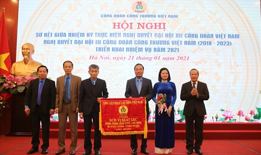 Phó Chủ tịch Tổng LĐLĐVN Trần Văn Thuật (thứ ba từ trái sang) và Thứ trưởng Bộ Công Thương (bên phải ảnh) tặng Cờ thi đua của Tổng LĐLĐVN cho Công đoàn Công Thương Việt Nam. Ảnh: Hà Anh