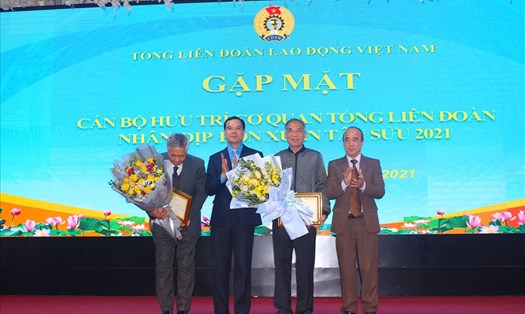 Chủ tịch Tổng LĐLĐVN Nguyễn Đình Khang (thứ hai từ trái sang) tặng hoa chúc mừng tròn 75 tuổi cho hai cán bộ hưu trí cơ quan Tổng Liên đoàn Lao động Việt Nam.