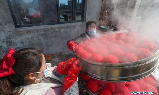 Dân làng Baiguo, ở tỉnh Quý Châu, Trung Quốc, hấp bánh Ciba đỏ, một loại bánh gạo nếp thường có trong dịp Tết Nguyên đán. Ảnh: Tân Hoa Xã.