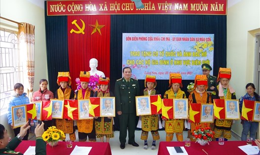 Bà con vùng biên giới nhận cờ Tổ quốc và ảnh Bác Hồ từ Bộ Chỉ huy Bộ đội Biên phòng tỉnh Lạng Sơn. Ảnh: V.T.