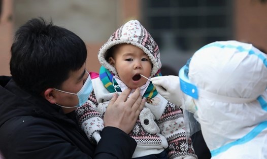 Một nhân viên y tế đang lấy mẫu xét nghiệm COVID-19 cho một em bé, trong chiến dịch xét nghiệm COVID-19 quy mô toàn thành phố đợt 3, tại Thạch Gia Trang, Trung Quốc. Ảnh: Tân Hoa Xã