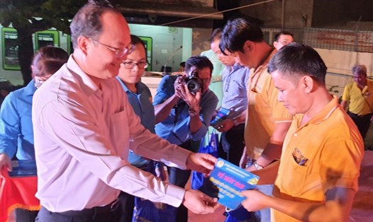 Ông Nguyễn Hồ Hải, Phó Bí thư Thành ủy TPHCM trao vé máy bay cho các công nhân lao động tiêu biểu. Ảnh Nam Dương