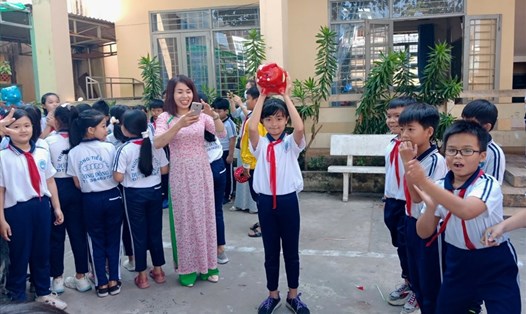 Niềm vui của các em học sinh trường Tiểu học Dương Đông 2 (thành phố Phú Quốc, Kiên Giang) khi chuẩn bị đập heo đất dành tiền giúp bạn. Ảnh: PV