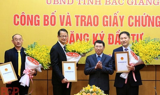 Chủ tịch UBND tỉnh Bắc Giang Lê Ánh Dương trao Giấy chứng nhận đăng ký đầu tư và tặng hoa chúc mừng các nhà đầu tư ngày 18.1.2021.Ảnh: BGP