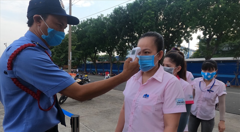 Doanh nghiệp ở Bình Dương thực hiện việc đo nhiệt độ công nhân trước khi vào nhà máy. Ảnh: Đình Trọng