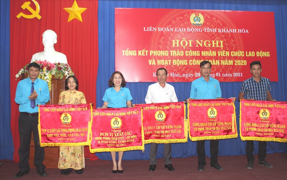 Lãnh đạo LĐLĐ Khánh Hoà trao cờ thi đua xuất sắc của Tổng Liên đoàn cho 5 đơn vị có nhiều hoạt động nổi bật trong năm qua. Ảnh: Phương Linh