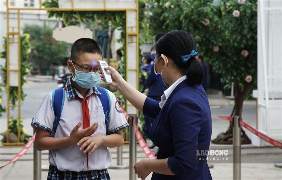 Học sinh được kiểm tra thân nhiệt, rửa tay bằng nước sát khuẩn trước khi vào trường. Ảnh minh hoạ: HP. Học sinh được kiểm tra thân nhiệt, rửa tay bằng nước sát khuẩn trước khi vào trường. Ảnh minh hoạ: HP.