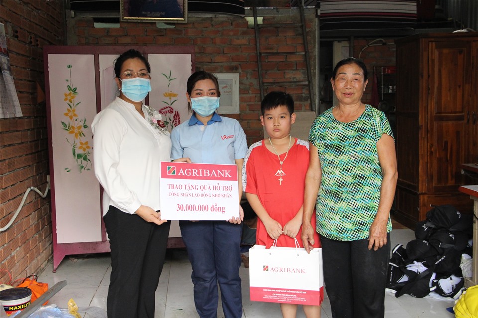 Bà Đỗ Thị Mai Tuyền - Giám đốc Agribank Chi nhánh Bình Dương đại diện trao phần tiền hỗ trợ cho gia đình nữ công nhân có hoàn cảnh khó khăn. Ảnh: Đình Trọng