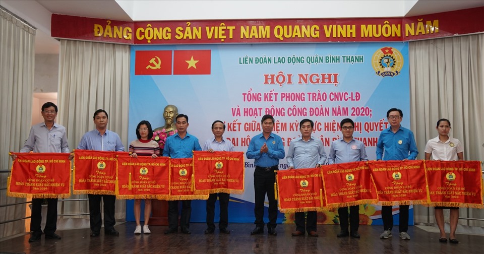 Phó Chủ tịch LĐLĐ TPHCM Phạm Chí Tâm (đứng giữa), tặng cờ thi đua cho các tập thể đạt thành tích xuất sắc. Ảnh LĐLĐ Bình Thạnh