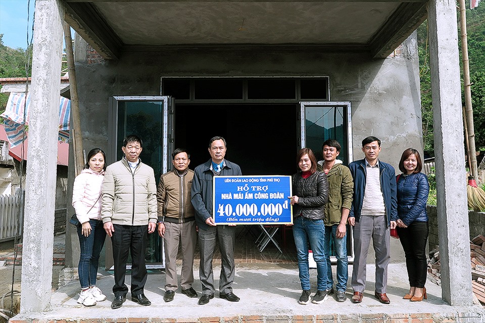 Ông Phạm Sơn - Phó Chủ tịch Thường trực LĐLĐ tỉnh trao số tiền hỗ trợ cho gia đình trước sự chứng kiến của LĐLĐ huyện và lãnh đạo xã Tân Lập. Ảnh: Anh Hoàng.