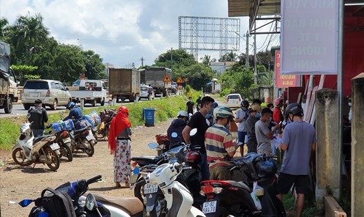 Người dân làm thủ tục khai báo y tế ở cầu 14 (giáp ranh tỉnh Đắk Nông) để vào địa phận tỉnh Đắk Lắk. Ảnh: Bảo Trung