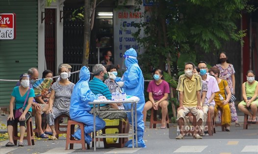 Cán bộ y tế lấy mẫu xét nghiệm COVID-19 cho người dân ở Hà Nội. Ảnh: Thế Kỷ