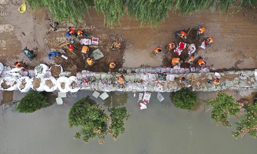 Ảnh chụp trên không cho thấy lực lượng cứu hộ đang gia cố môt con đê tạm thời để chống lũ lụt tại làng Lianbo ở thành phố Hejin, thuộc tỉnh Sơn Tây, miền bắc Trung Quốc, ngày 10.10.2021. Ảnh: Tân Hoa Xã