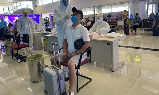 Lấy mẫu xét nghiệm nhanh COVID-19 cho hành khách tại sân bay Nội Bài. Ảnh CDC